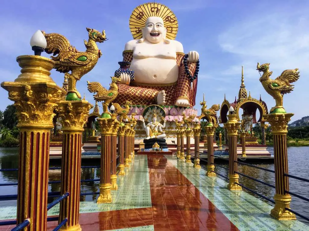 Fat Buddha: Who is the Laughing Buddha 5 Fat Buddha statue at Wat Plai Laem on Koh Samui I Photo taken by WorldTravelConnector.com I Skinny Buddha vs Fat Buddha I buddha laughing I hotei buddha I laughing buddha I statue of laughing buddha I laughing buddha statue I happy buddha statue I budai I Chinese Jolly Buddha
