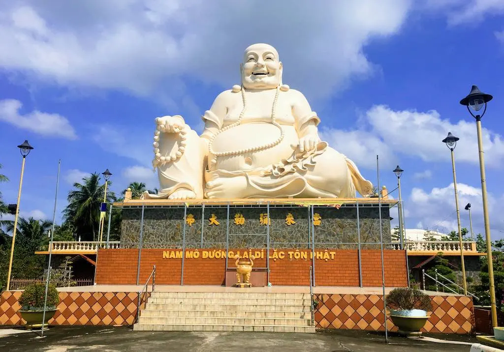 Fat Buddha: Who is the Laughing Buddha 3 Skinny Buddha vs Fat Buddha_Fat Buddha statue at Vinh Trang Temple in Mekong Delta in Vietnam, the photo taken by WorldTravelConnector.com I buddha laughing I hotei buddha I laughing buddha I statue of laughing buddha I laughing buddha statue I happy buddha statue I budai I Chinese Jolly Buddha