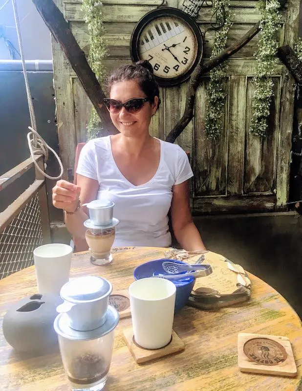 Coffee in Vietnam: Vietnamese Coffee Types You Must Try in Vietnam 13 Vietnamese drip coffee is one of traditional types of Vietnamese coffee I Milijana Gabric from WorldTravelConnector.com drinking traditional Vietnam drip coffee in Vietnam I Traditional Vietnamese drip coffee I types of Vietnam coffee