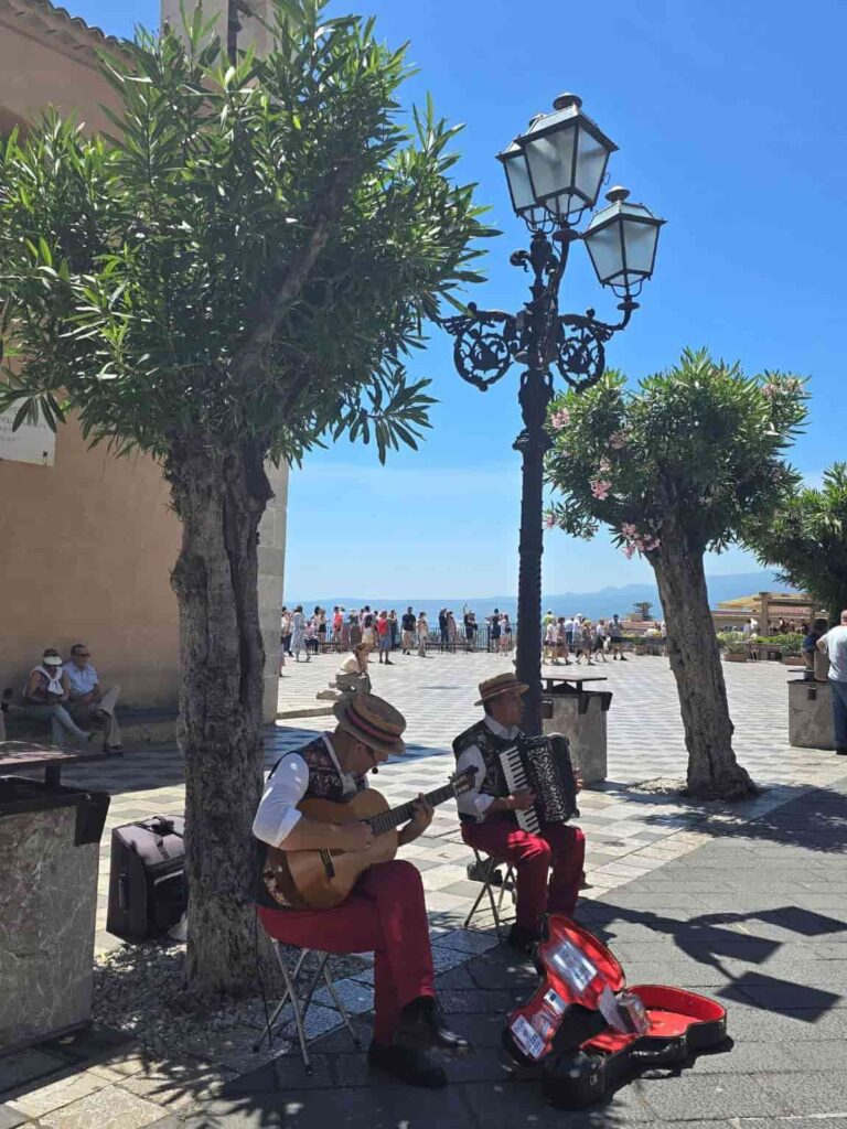 Planning A Trip To Sicily? Don’t Miss These 23 Bucket List Things to do in Taormina! 3 Street musicians in the Corso Umberto in Taormina, Itay. Strolling the vibrant Corso Umberto is among the best things to do in Taormina Italy
