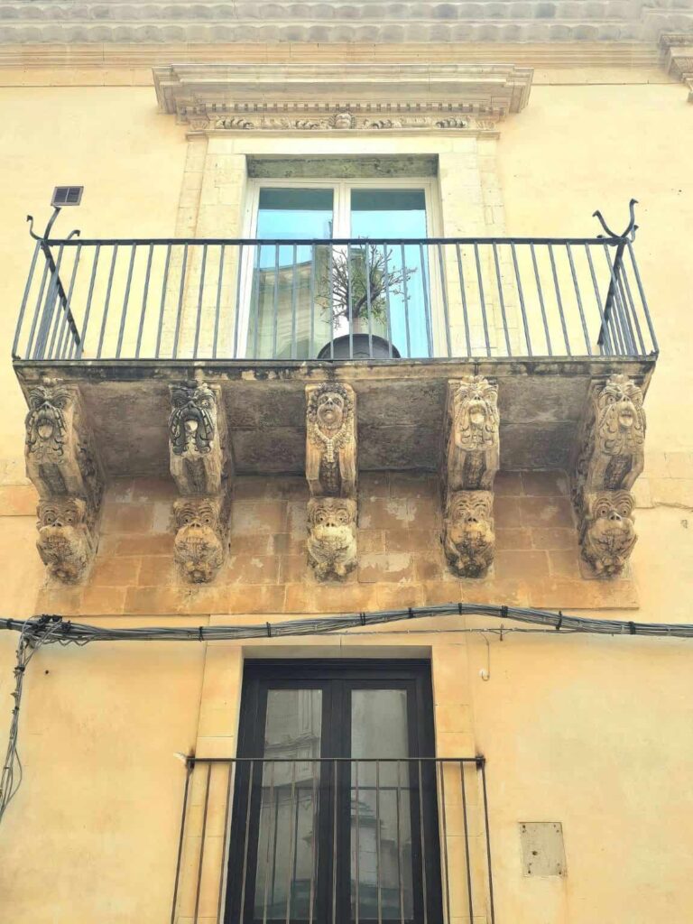 Why Noto Italy, the Capital of Sicilian Baroque, Is Your Next White Lotus-Inspired Getaway 9 A balcony of Nicolaci (Villadorata) Palace in Noto, Sicily