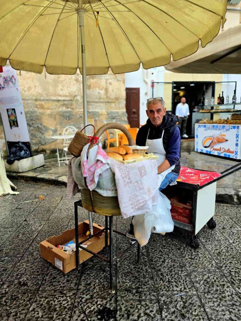 Discover the Most Amazing Palermo Food Markets — 3 Must-Visit Spots! 9 A bread seller at the Capo market in Palermo. Capo is oneof the best Palermo food markets.
